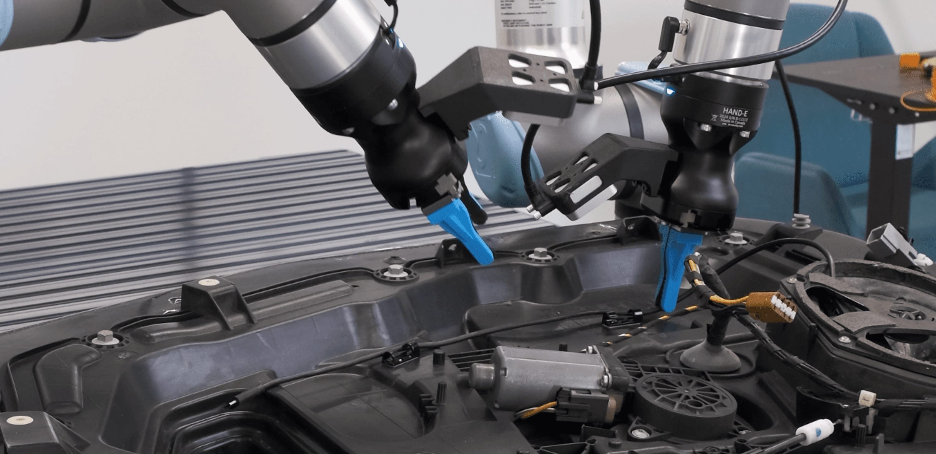 Standard industrial arms handling a delicate, deformable assembly task, learned on Neuracore.
