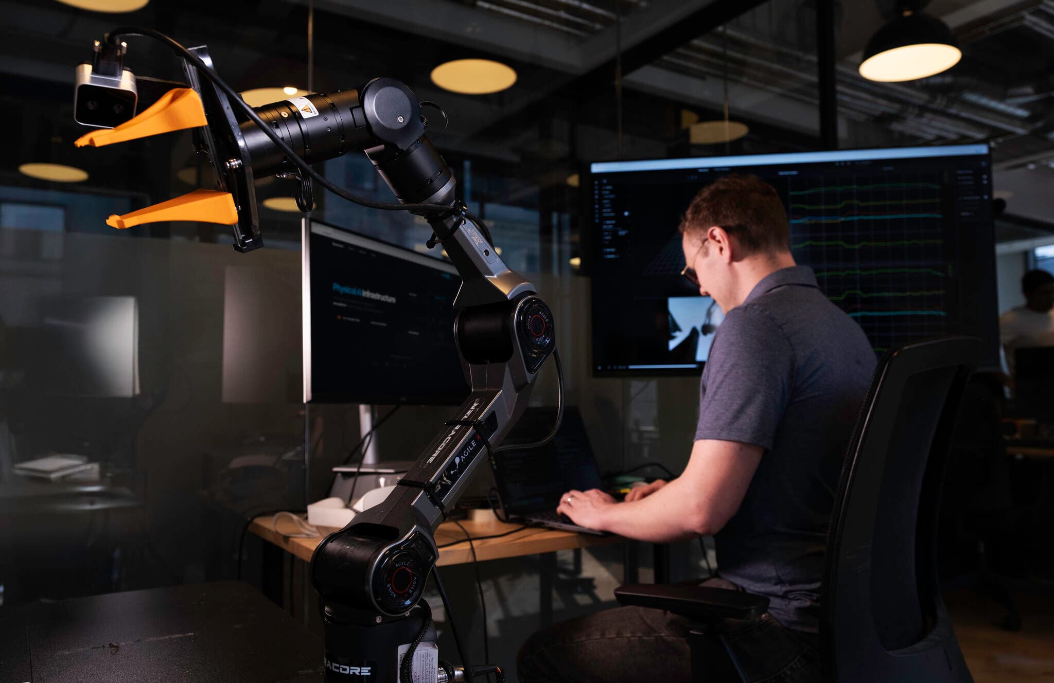 Engineer at a workstation with a robot arm
